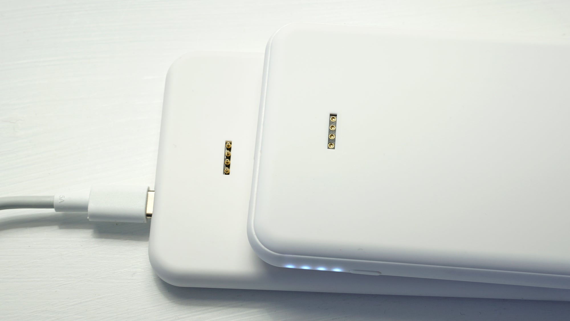 The power bank charges on the pad using a series of metal pins instead of wireless power transfer.