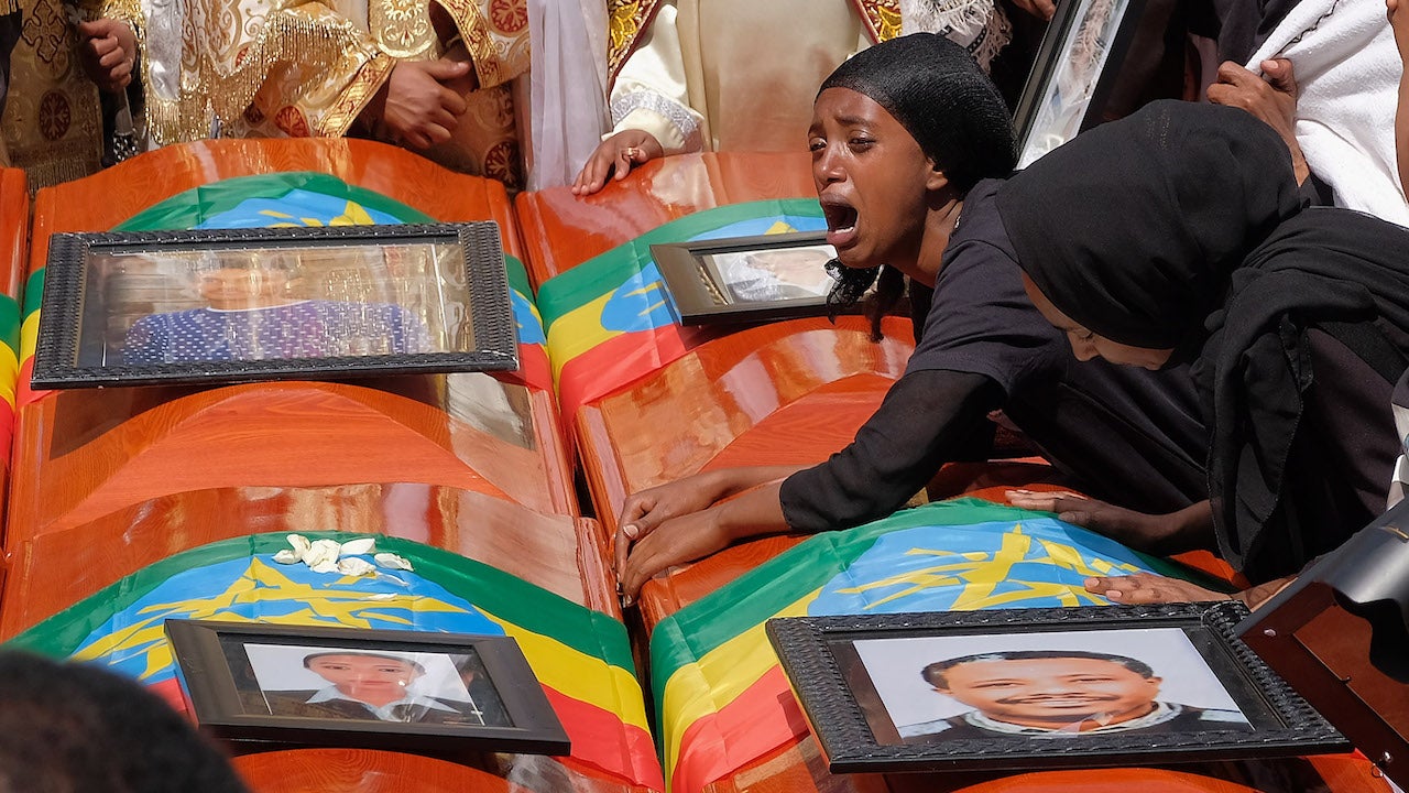 A woman lays on the coffin of her loved one during a memorial service for the Ethiopian passengers and crew who died on Flight 302
