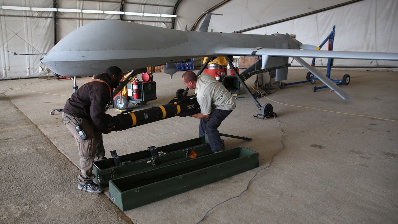 Contract workers load a Hellfire missile onto a U.S. Air Force MQ-1B Predator unmanned aerial vehicle (UAV), at a secret air base in the Persian Gulf region on January 7, 2016.