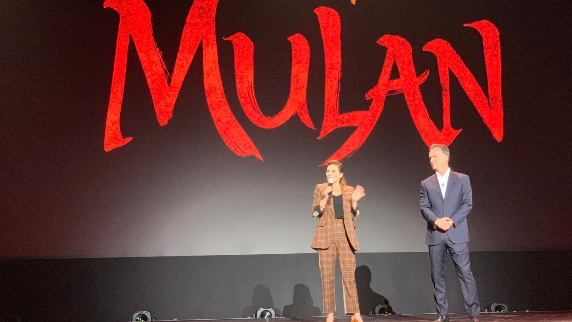 Mulan director Niki Caro, and Disney executive Sean Bailey, on stage at the D23 Expo.
