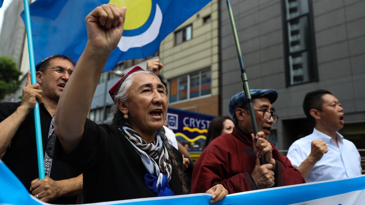 Rebiya Kadeer, president of the World Uyghur Congress (WUC) and people chant slogans and wave flags during a protest march on June 29, 2019 in Osaka, Japan.
