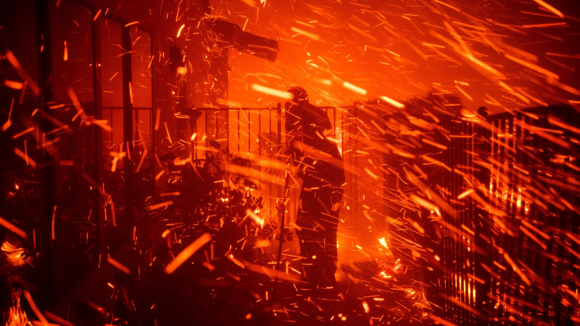 Jerry Rowe uses a garden hose to save his home from the Saddleridge fire in Granada Hills, California, Friday, October 11, 2019.