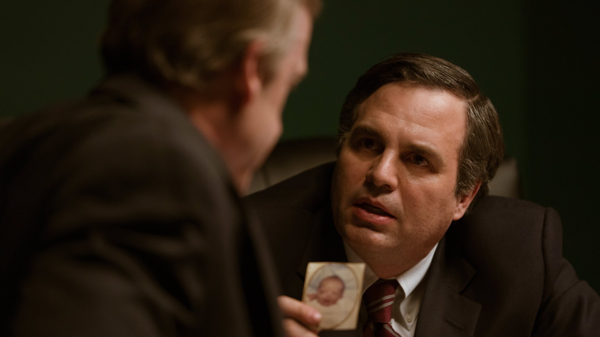 Rob Bilott (played by Mark Ruffalo) shows DuPont CEO a photo of Bucky Bailey, a baby born with a defect due to in-utero exposure to PFOA, in “Dark Waters.”