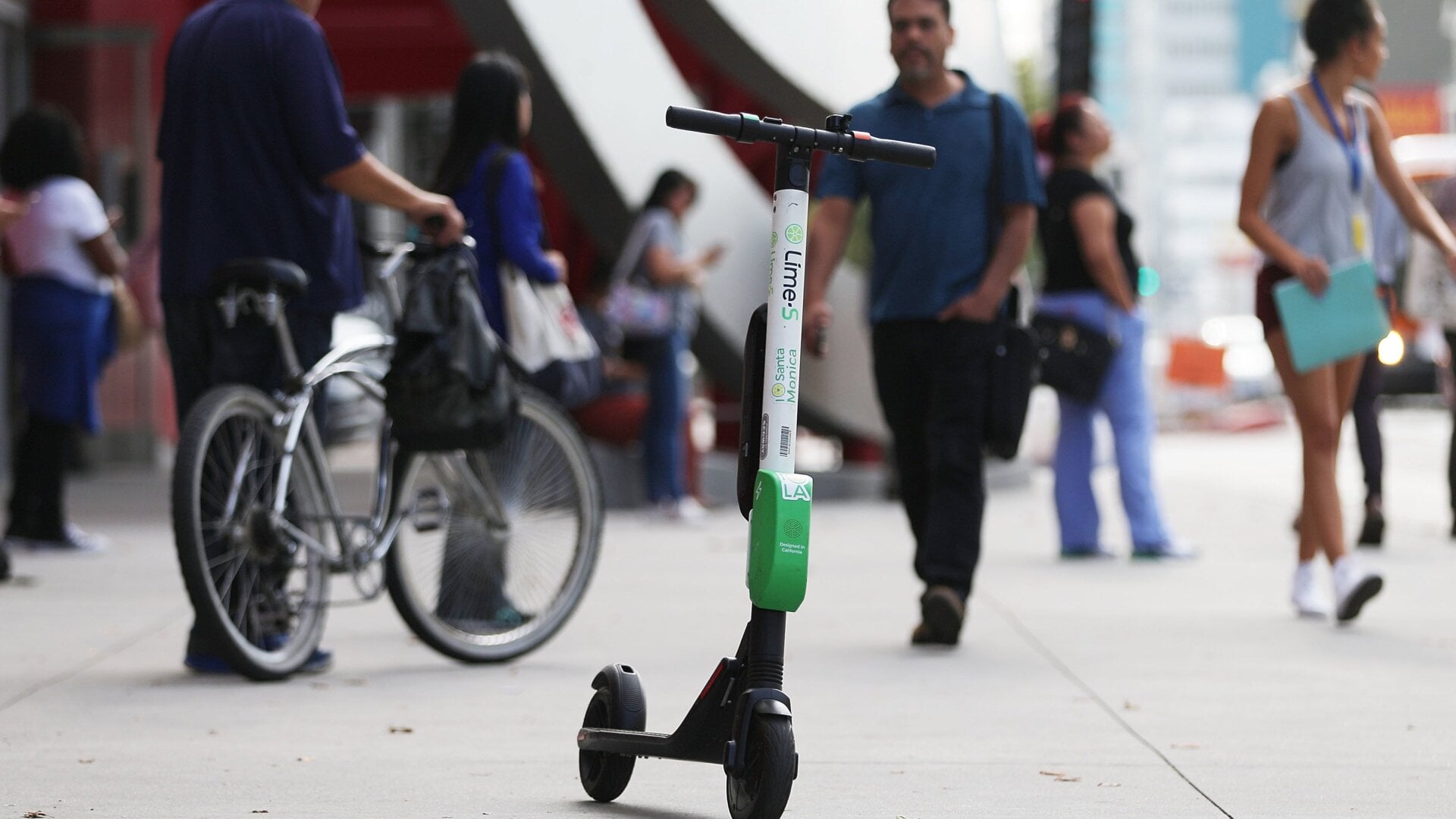 A Lime dockless electric scooter is parked on a Wilshire Boulevard sidewalk, available for its next rider, on July 9, 2018 in Los Angeles, California.