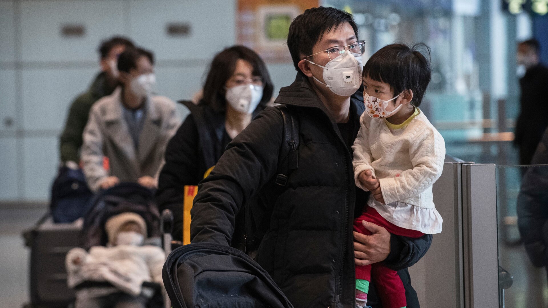 Passengers wear protective masks in the arrivals area at Beijing Capital Airport on January 30, 2020.