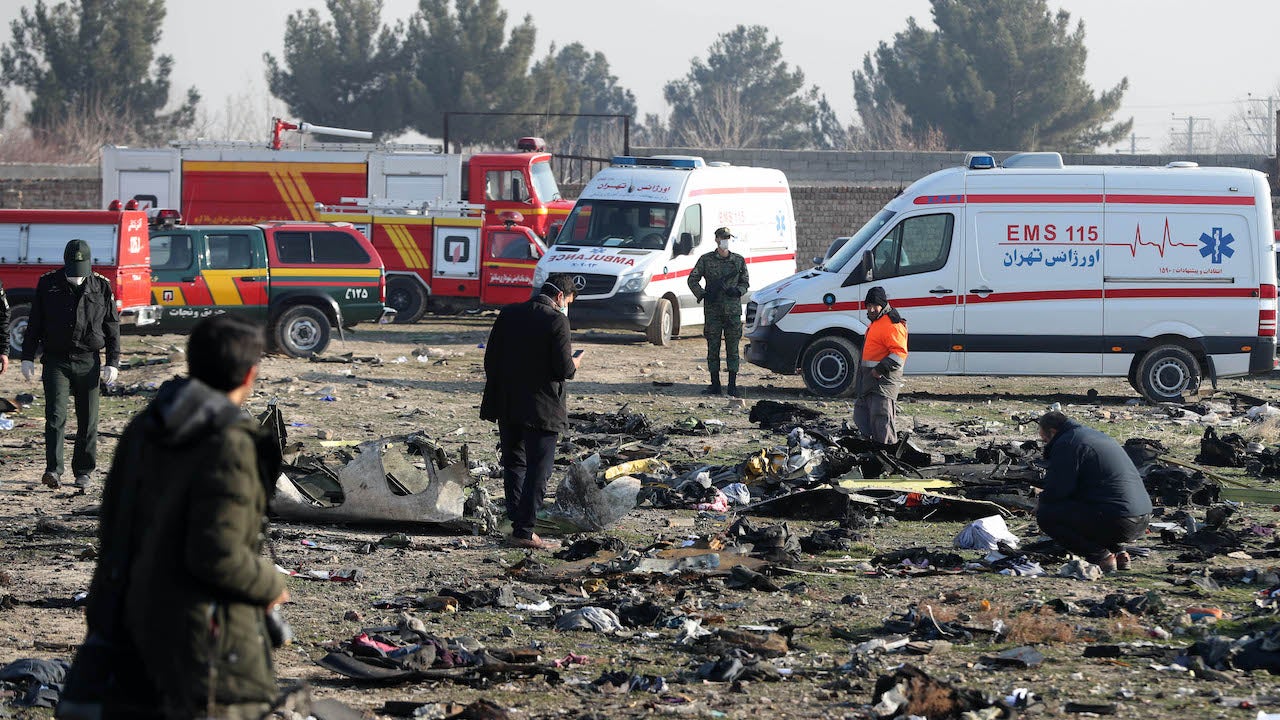 Rescue teams work amidst debris after a Ukrainian plane carrying 176 passengers crashed near Imam Khomeini airport in the Iranian capital Tehran early in the morning on January 8, 2020