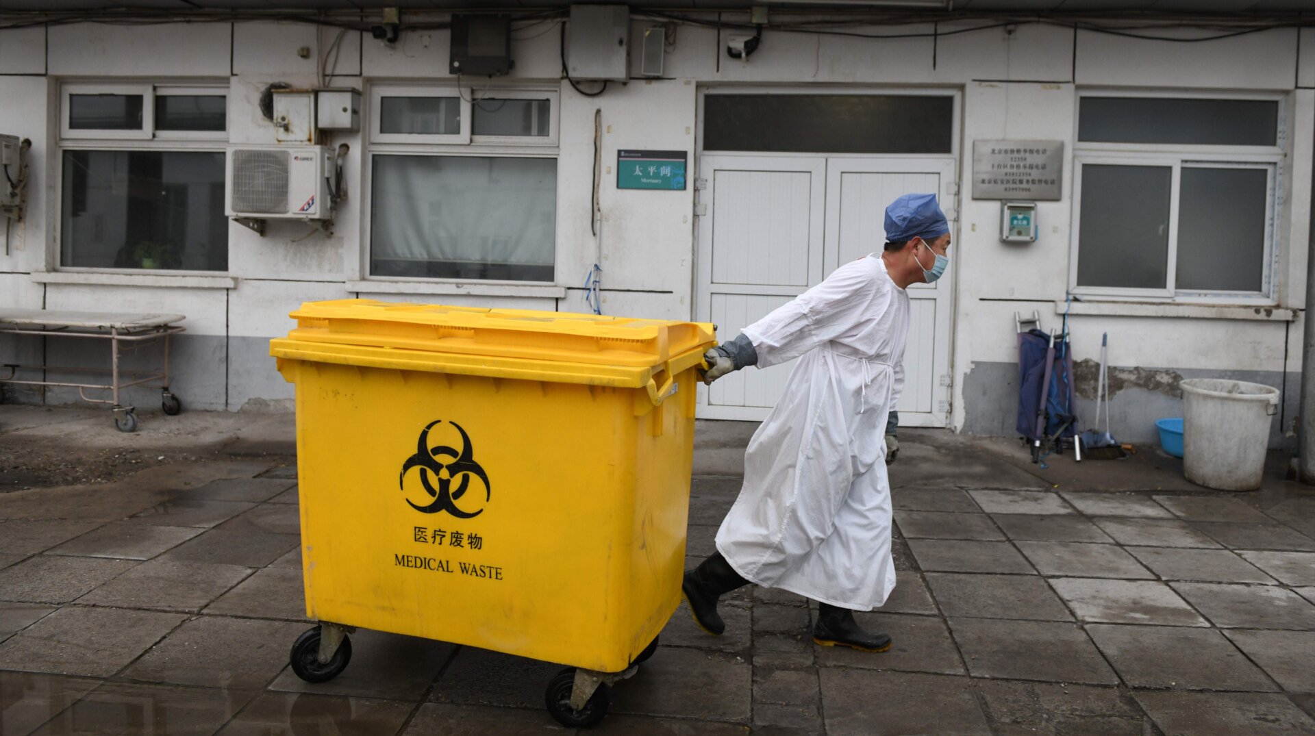 A health care worker moves medical waste past a mortuary at Youan Hospital in Beijing, China on February 14, 2020.