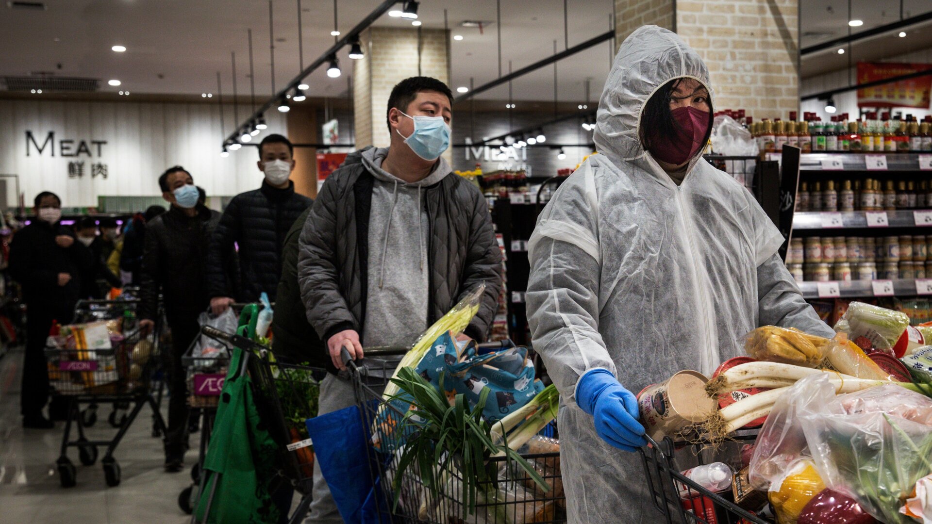 Residents wear protective masks as they line up in a grocery store on February 12, 2020 in Wuhan, China.