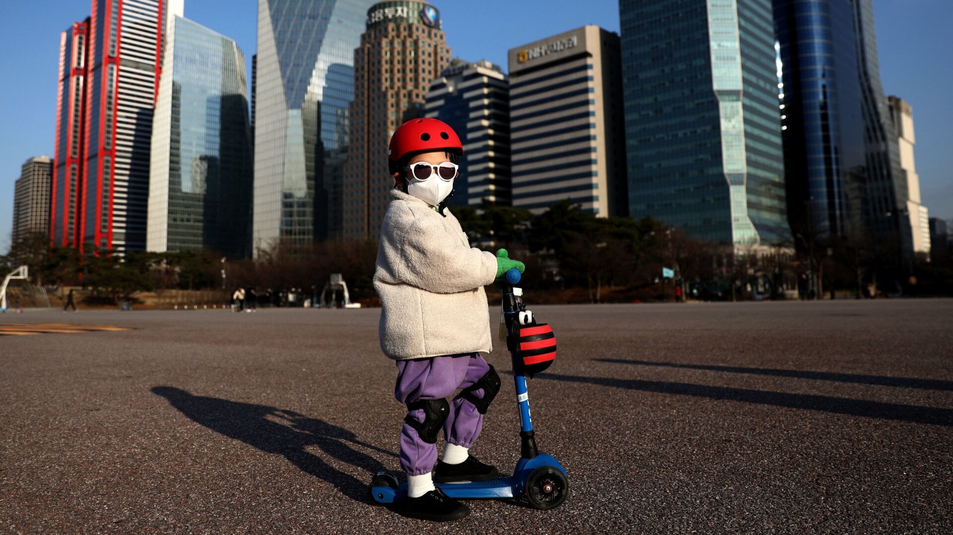 A child wears a mask to prevent catching the new coronavirus while riding a scooter on February 27, 2020 in Seoul, South Korea.