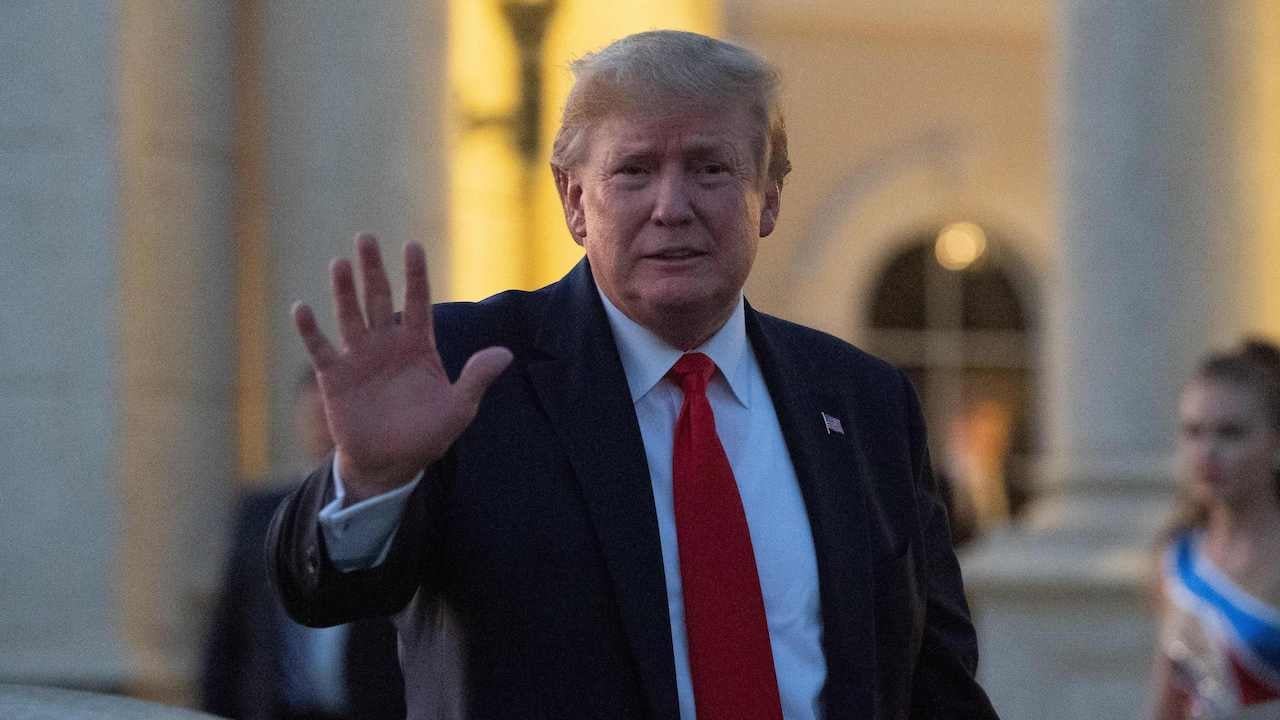 Donald Trump waves at the Trump International Golf Club as he arrives for a Super Bowl viewing party in West Palm Beach on February 2, 2020.