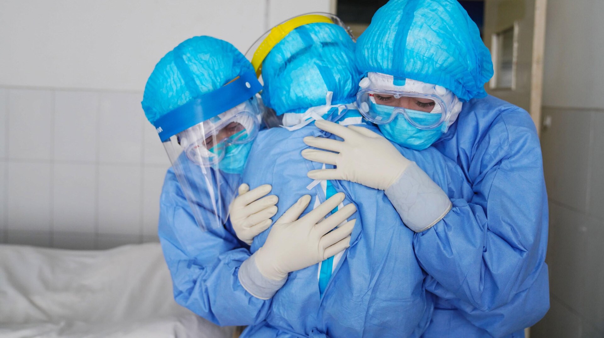 This photo taken on January 28, 2020 shows medical staff members hugging each other in an isolation ward at a hospital in Zouping in China’s easter Shandong province.