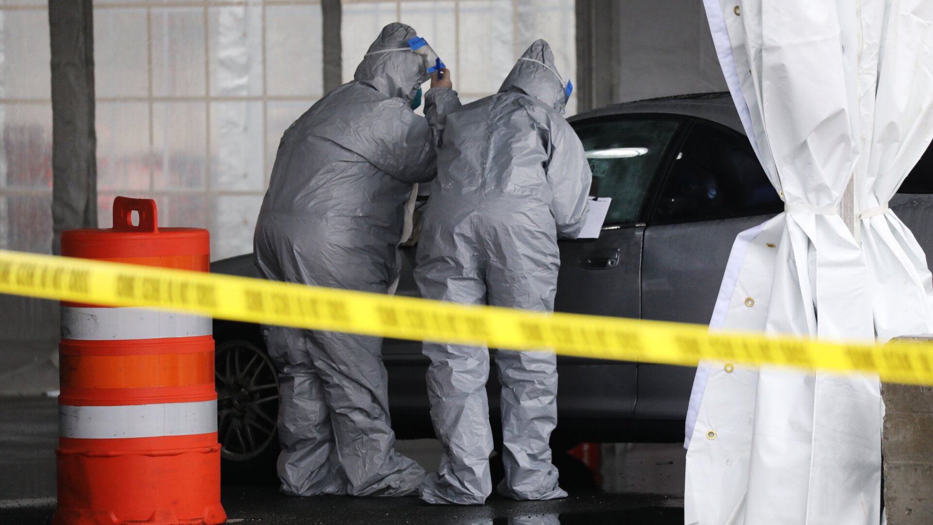 Workers in protective gear operate a drive through COVID-19 mobile testing center on March 13, 2020 in New Rochelle, New York.
