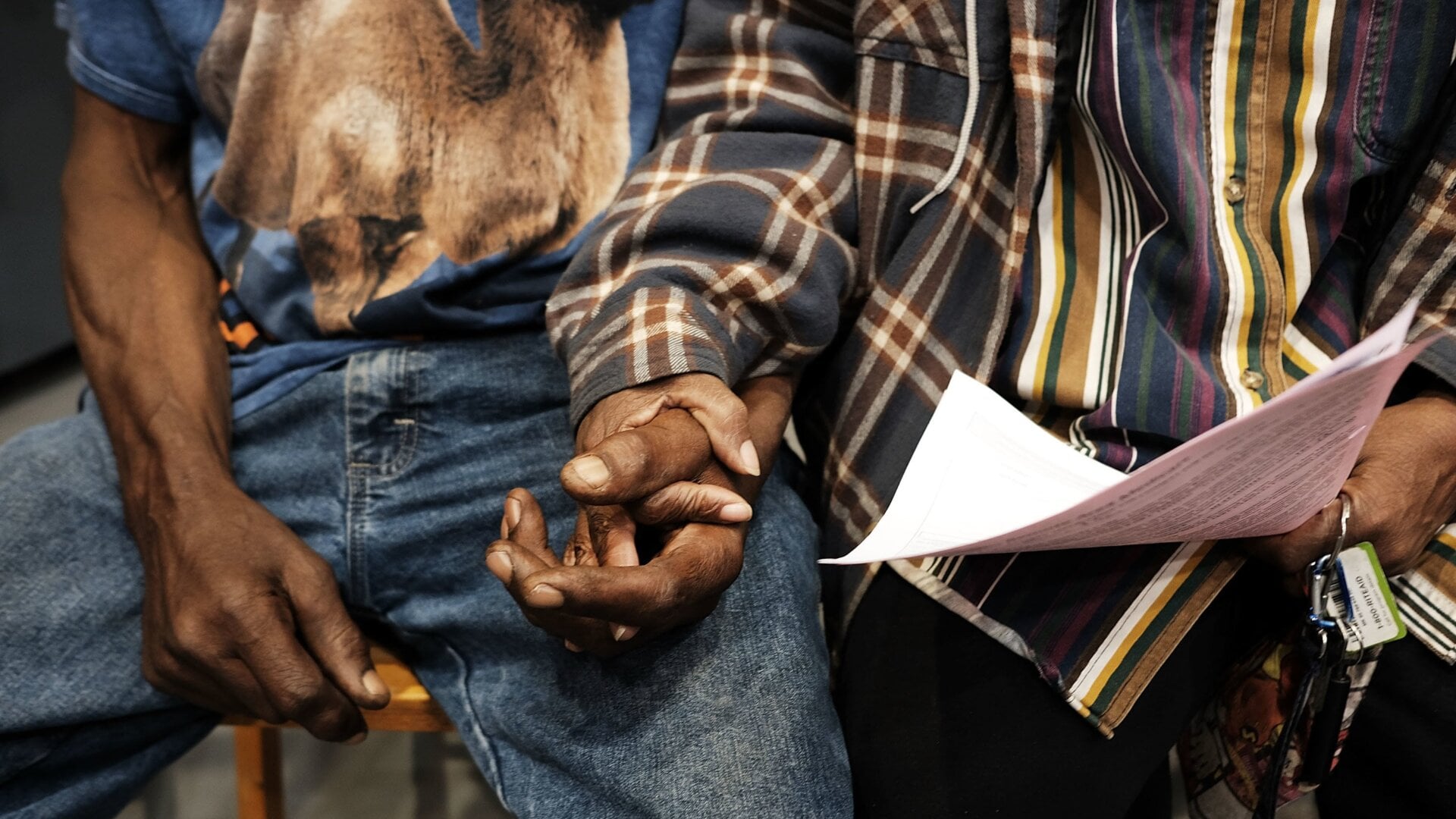 A couple hold hands while to see a doctor at the Remote Area Medical (RAM) mobile dental and medical clinic in Olean, New York. (June 10, 2017)