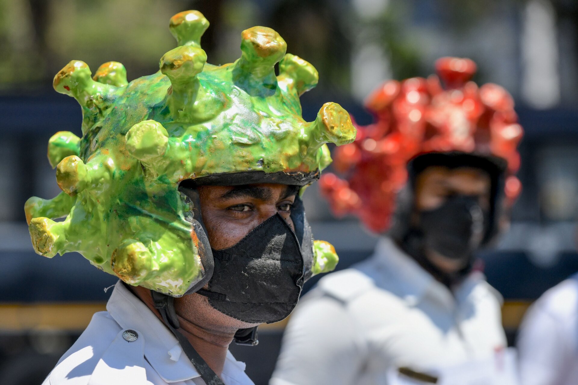 Traffic police personnel wearing coronavirus-themed helmets participate in a campaign to educate the public during a government-imposed nationwide lockdown as a preventive measure against the COVID-19 coronavirus in Bangalore on March 31, 2020. 