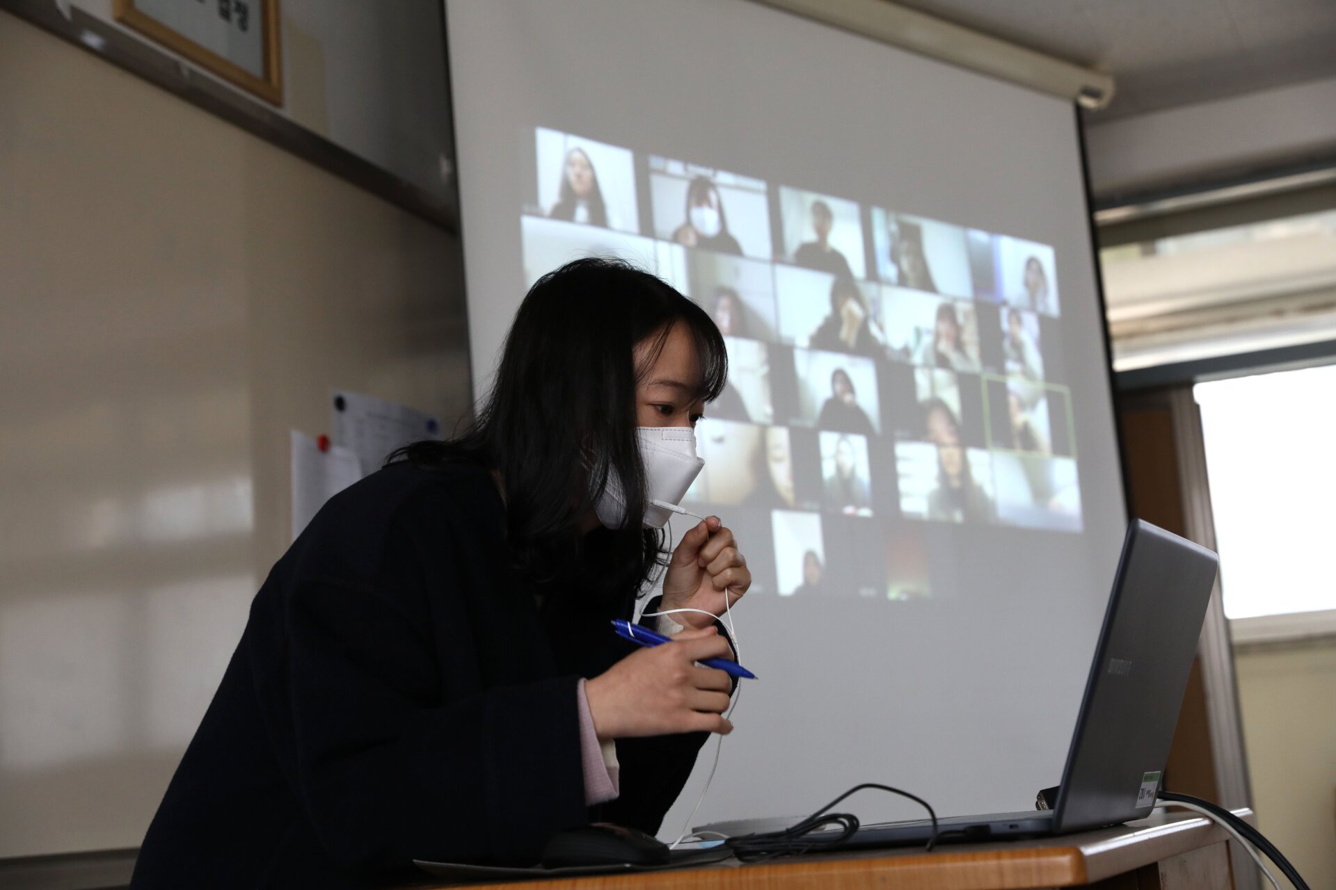 A teacher wears a mask as she gives a lesson on the first day of online class in an empty classroom as South Koreans take measures to protect themselves against the spread of coronavirus (COVID-19) at Seoul Girls High School on April 09, 2020 in Seoul, South Korea.