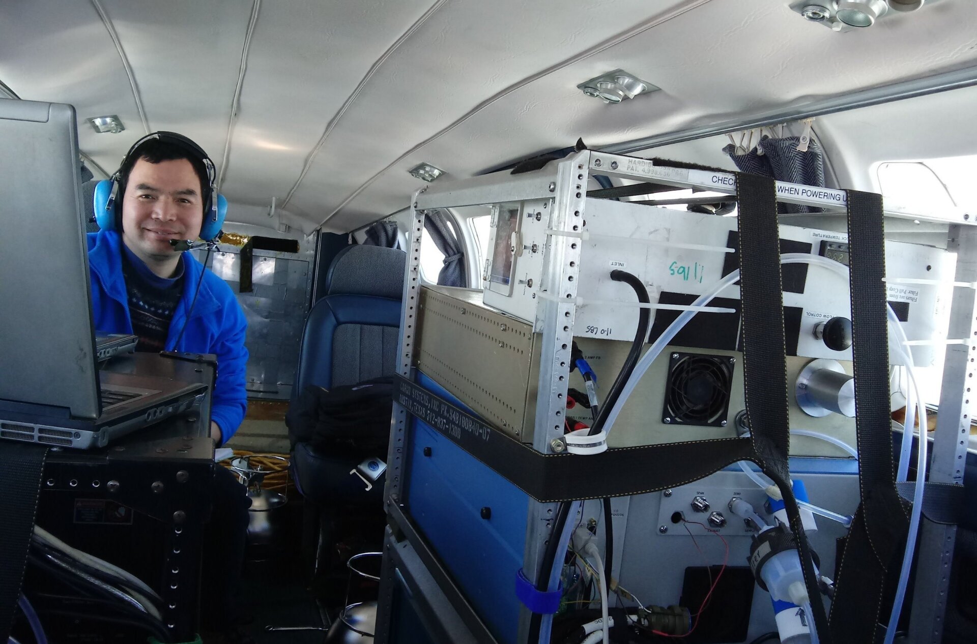 University of Maryland Research Scientist Xinrong Ren with a suite of atmospheric scientific instruments inside a research aircraft Cessna 402.