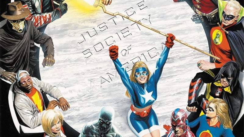 Members young and old stand together around a familiar JSA table.