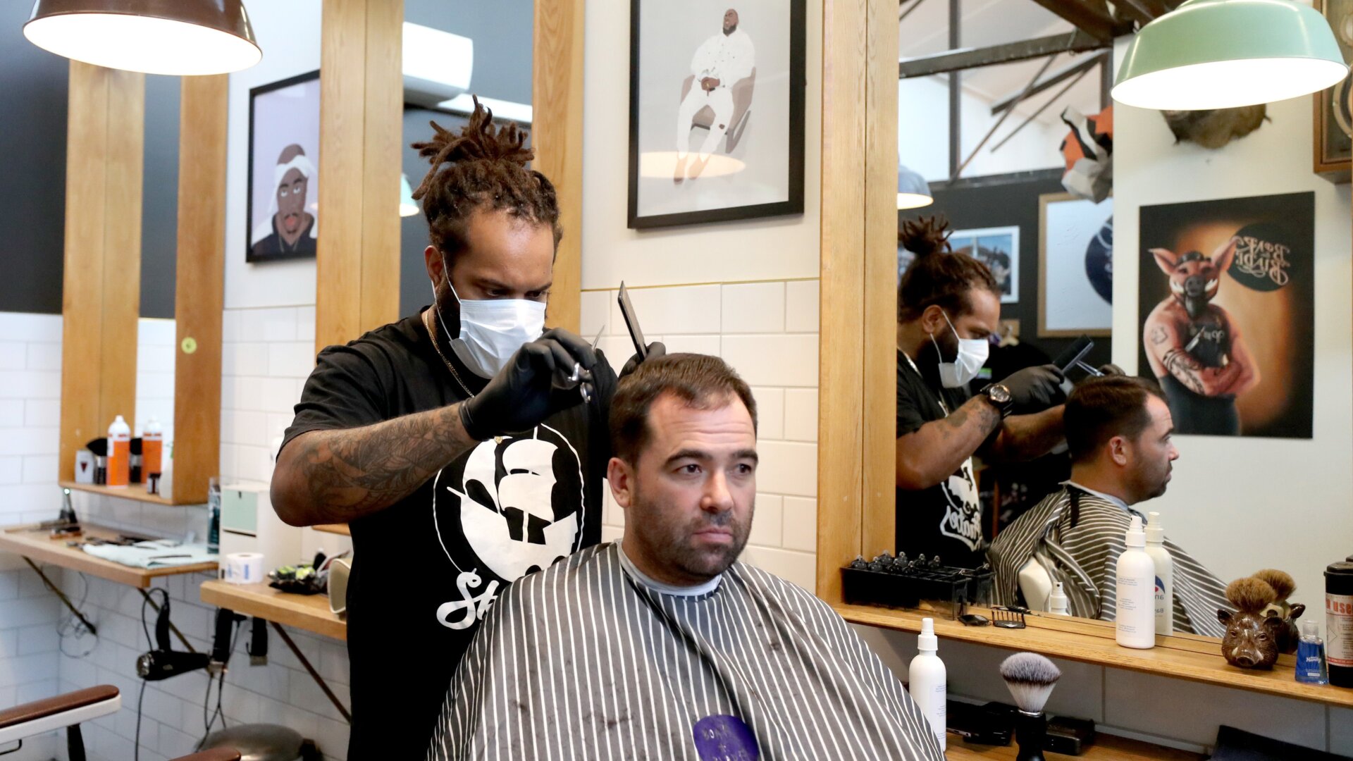 A barber wearing a face mask works on a customer’s hair at Board & Blade  on May 14, 2020 in Auckland, New Zealand.