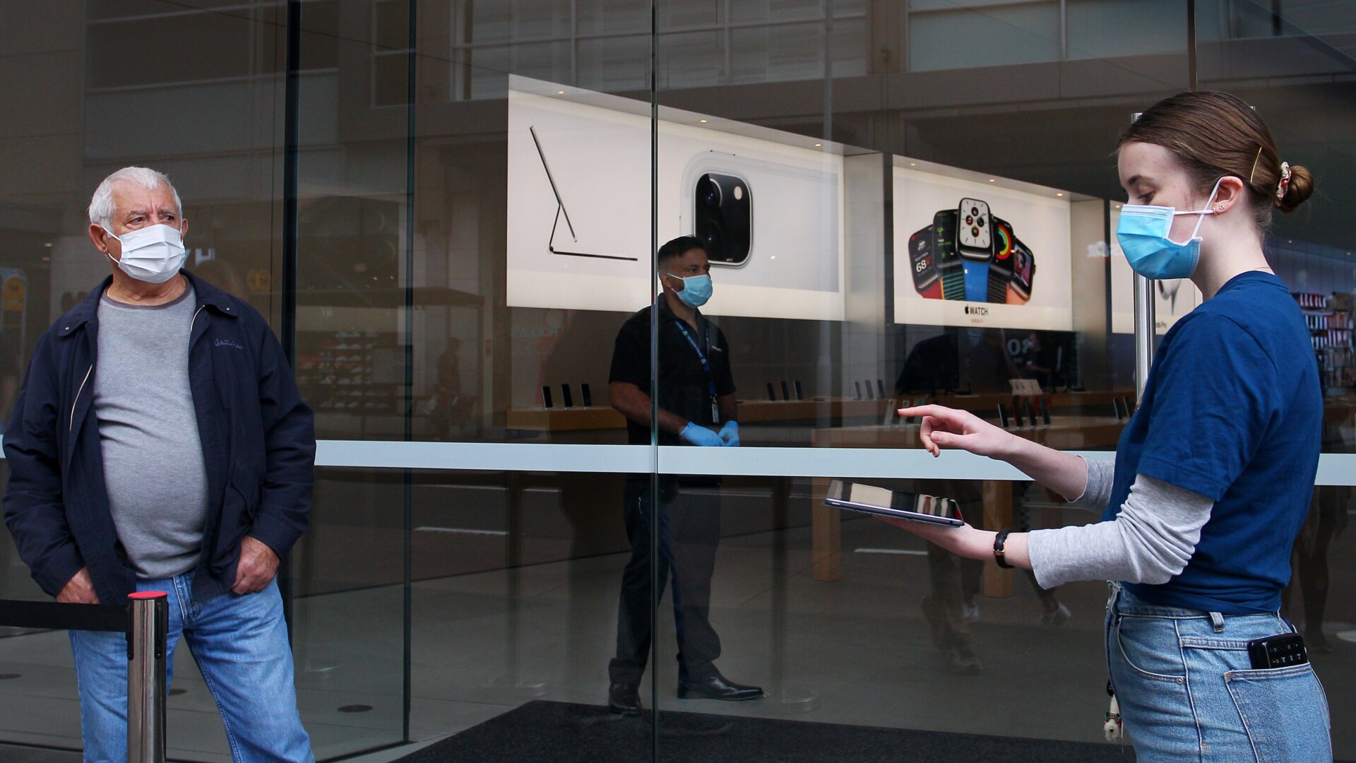 A staff member assists a customer prior to entering the Bondi Junction Apple Store on May 07, 2020 in Sydney, Australia.
