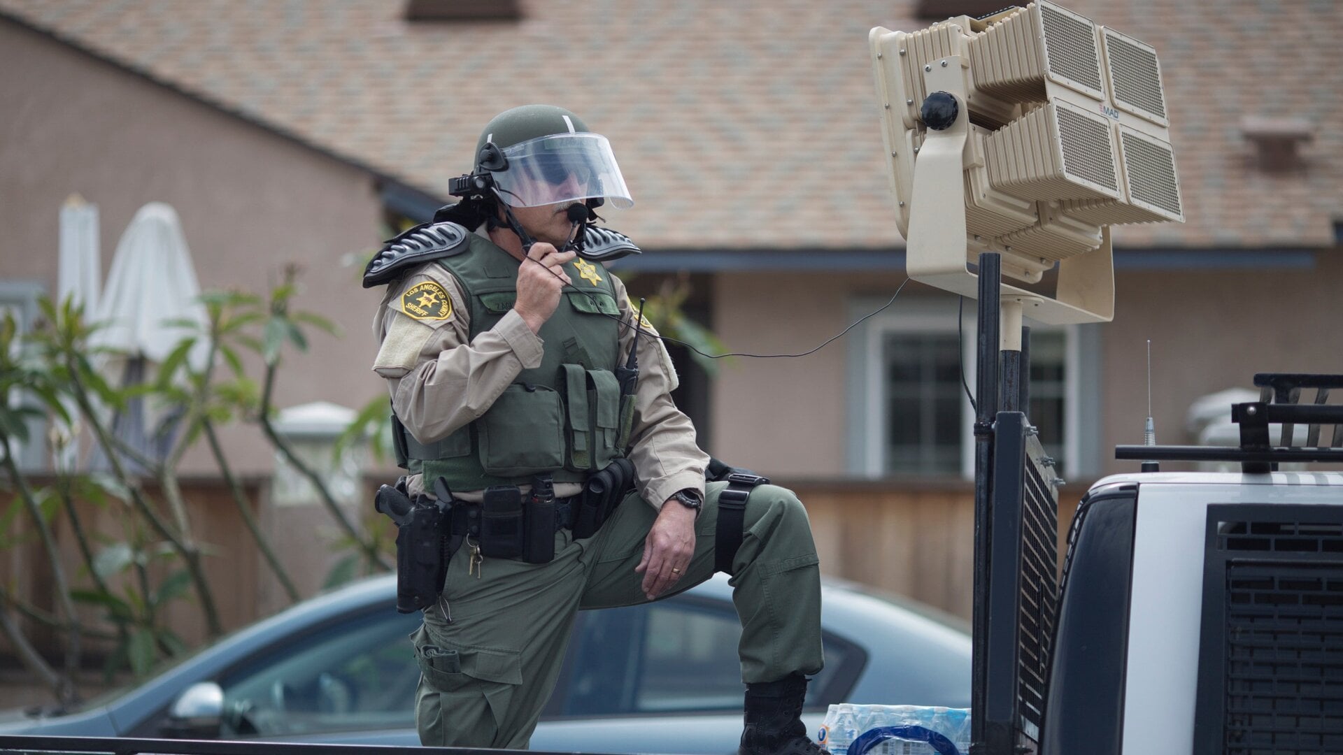 In this photo taken at a 2016 protest, a Los Angeles County Sheriff’s deputy in riot gear stands ready to use a sound cannon, or long-range acoustic device (LRAD), against demonstrators near a Donald Trump campaign rally in Anaheim, California.