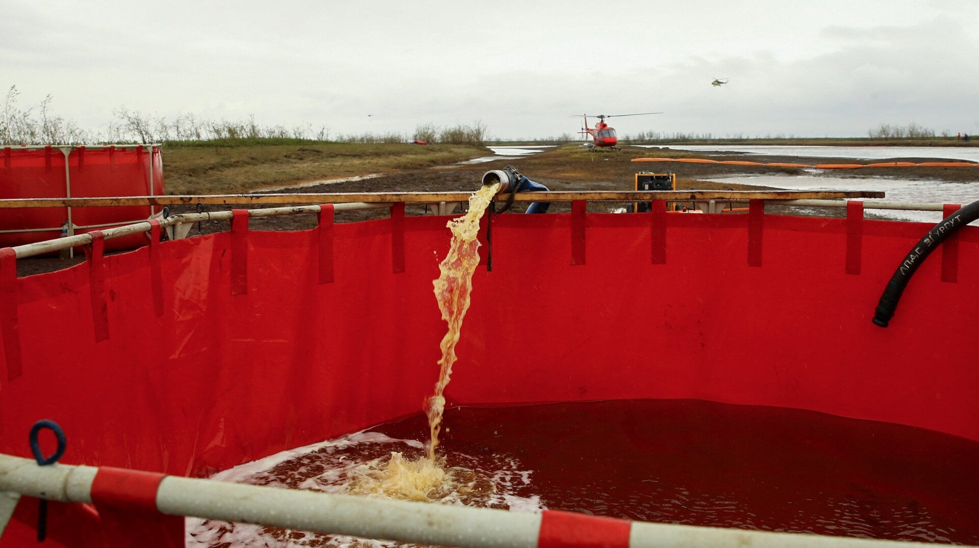 Spilled diesel fuel dredged from the river being poured into containment tanks. 