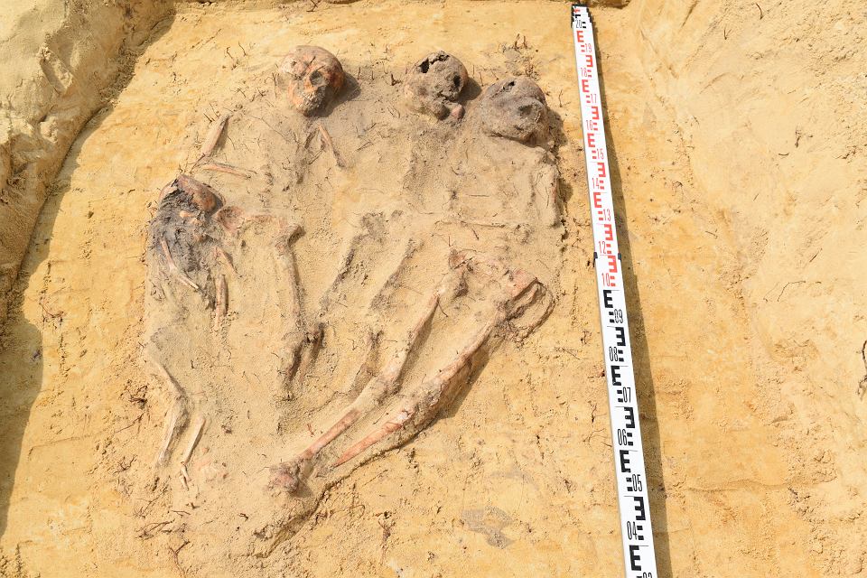 A grave containing four children, laid side-by-side, with legs and feet meeting together. 