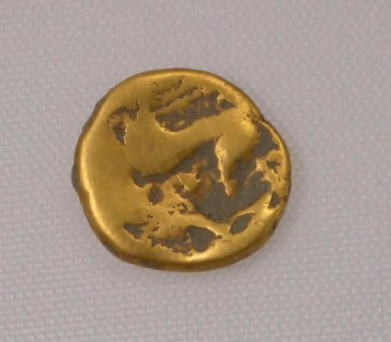 An uninscribed gold stater coin found at the site. 