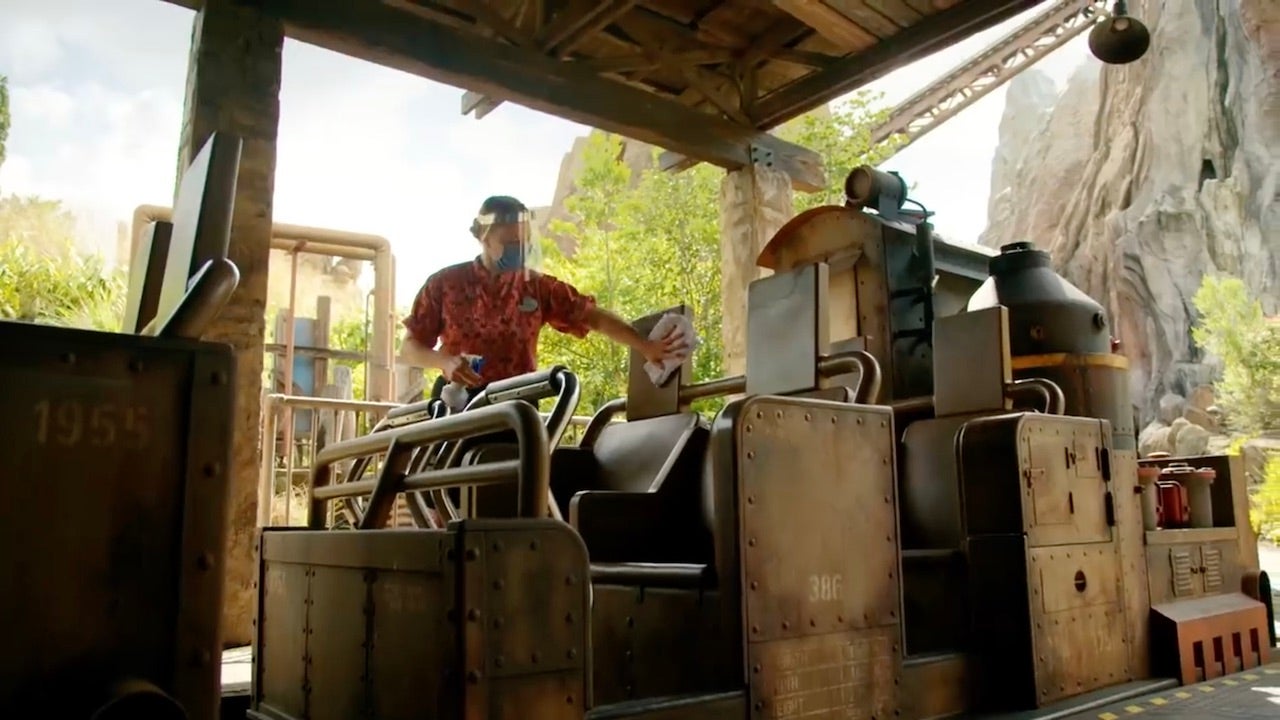 A Disney cast member wipes down a ride vehicle in a new video released by Disney Parks on YouTube.