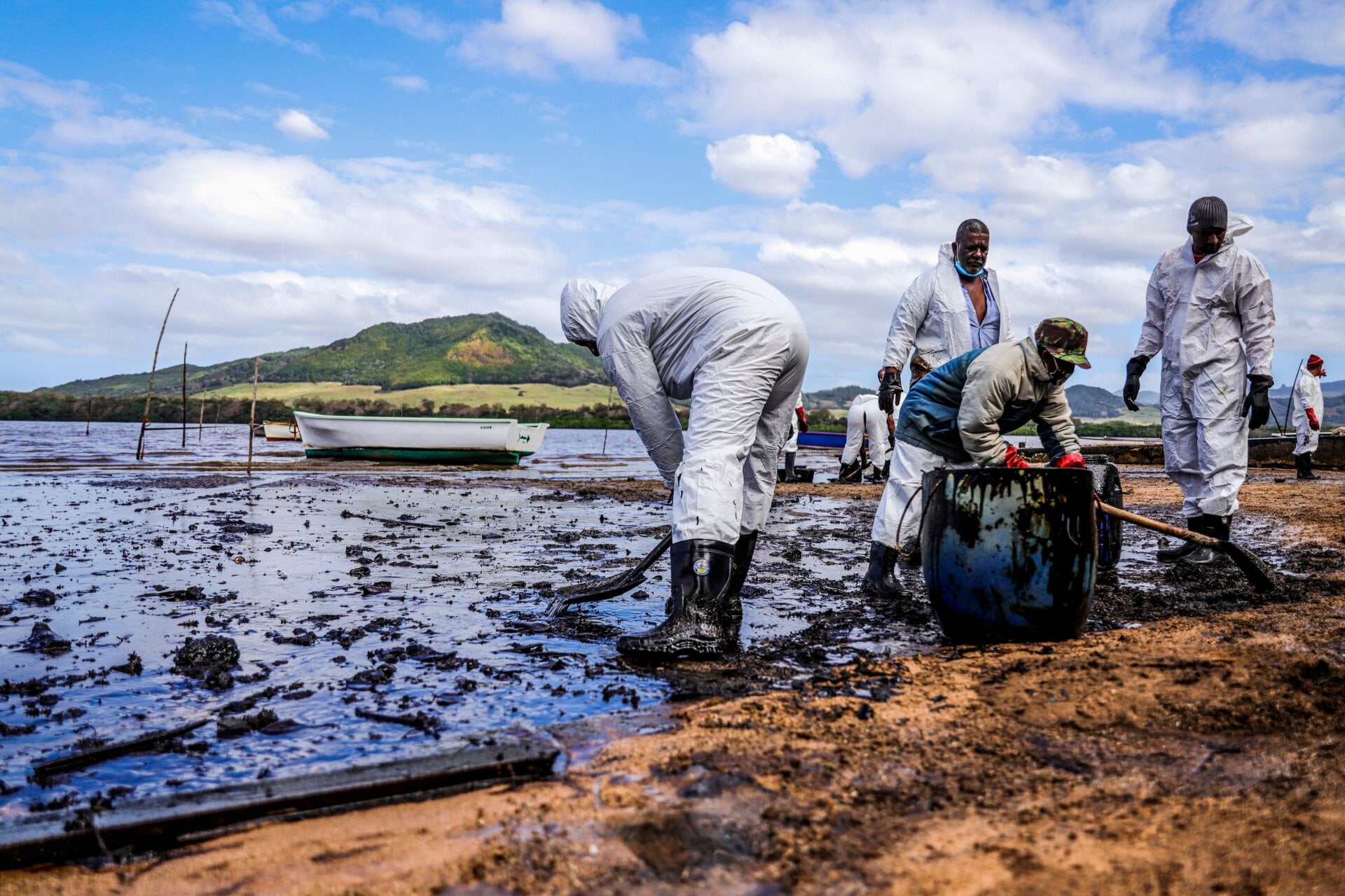 People scoop leaked oil near Blue bay Marine Park in southeast Mauritius on August 9, 2020