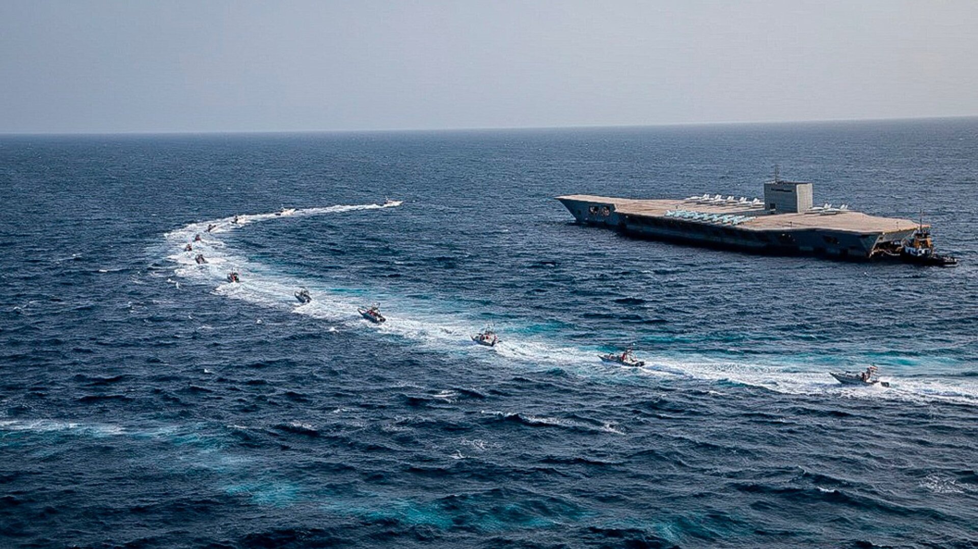 IRGC speedboats circling a mock aircraft carrier during exercises in a photo released on July 28, 2020. This photo was released by the IRGC and cannot be independently verified.
