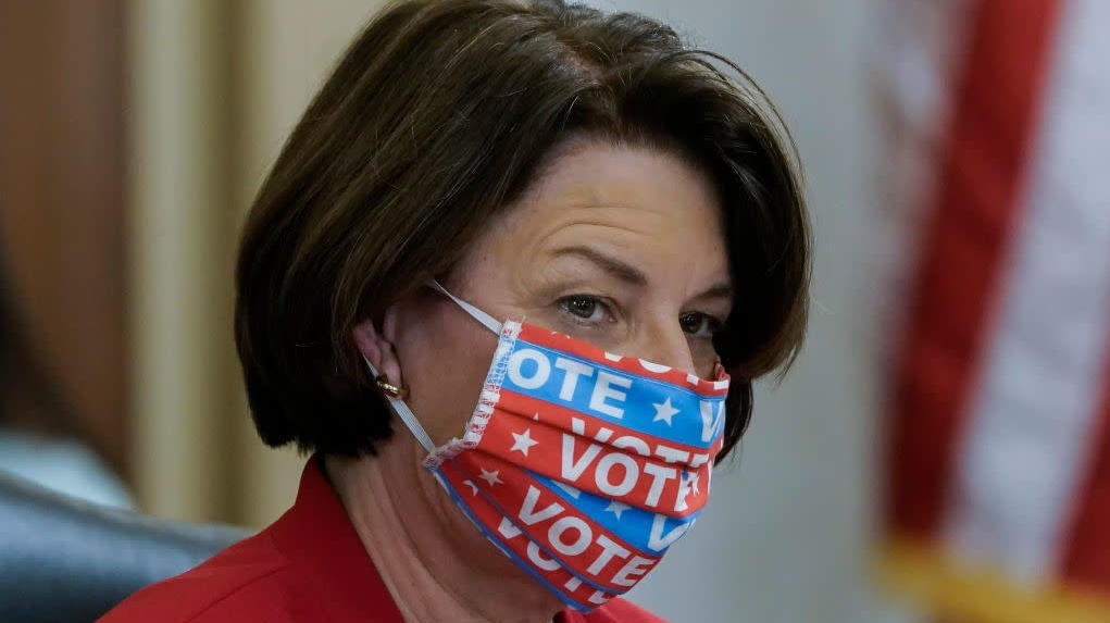 Sen. Amy Klobuchar wears a face mask that says “VOTE” during a Senate Rules Committee hearing.