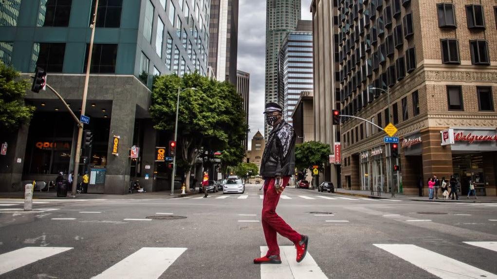 A man wearing a mask walks in downtown Los Angeles on March 22, 2020.