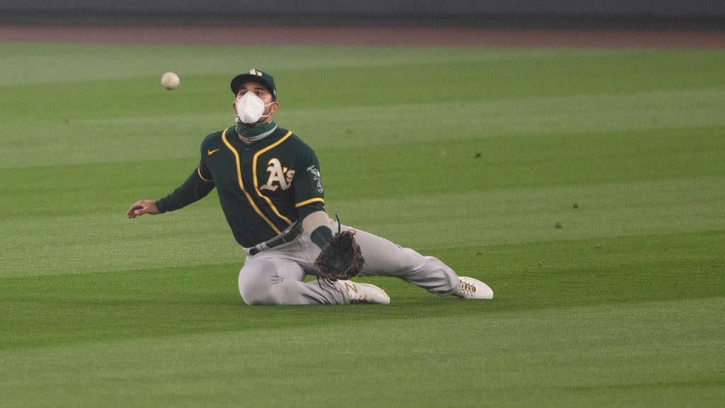 Ramon Laureano of the Oakland Athletics wears an N95-style mask as he catches a pop fly in the second inning of the first game of a doubleheader at T-Mobile Park on September 14, 2020, in Seattle, Washington. 