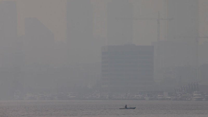 A woman sits on a boat at Madison Park Beach as smoke from wildfires on the West Coast fills the air on September 11, 2020 in Seattle, Washington.