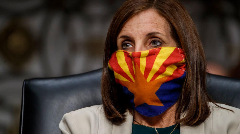 Sen. Martha McSally wears a mask depicting the Arizona state flag as she listens to testimony during the Senate Armed Services Committee hearing.