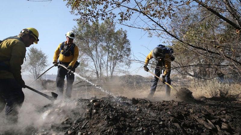 Firefighters Kyle Parker (L), Battalion Chief Bob Horst (C) and Sam Hochstatter from the Grant County Fire Department work to secure the fire line on the Cold Springs Fire on September 10, 2020 in Omak, Washington. 