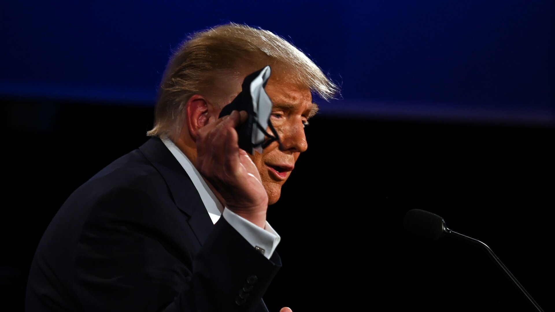 U.S. President Donald Trump holds a face mask as he speaks during the first presidential debate.