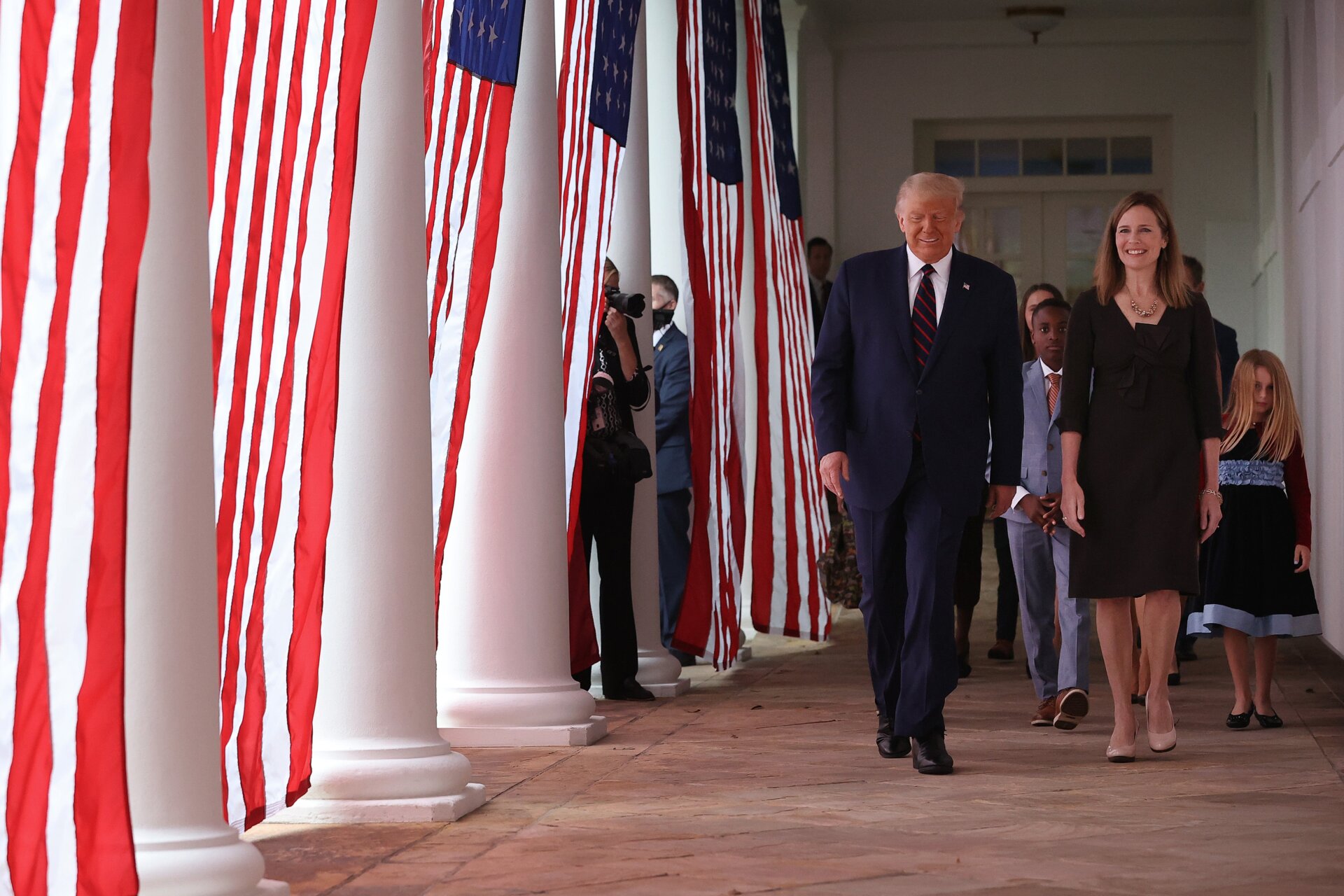President Donald Trump, 7th U.S. Circuit Court Judge Amy Coney Barrett, and her family walk along the Rose Garden Colonnade after Trump announced Barrett as his nominee for the Supreme Court.