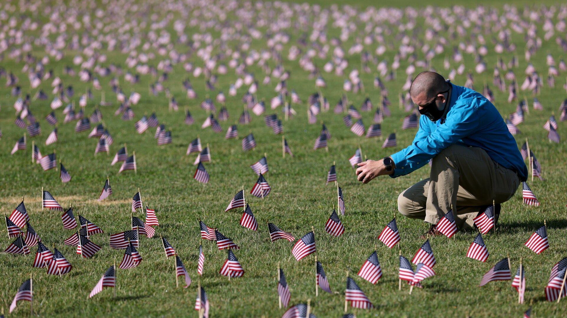 Chris Duncan, whose 75-year-old mother Constance died from the viral illness, photographs a COVID Memorial Project installation of 20,000 American flags meant to mourn the then 200,000 U.S. lives lost in the pandemic on September 22, 2020 in Washington, DC