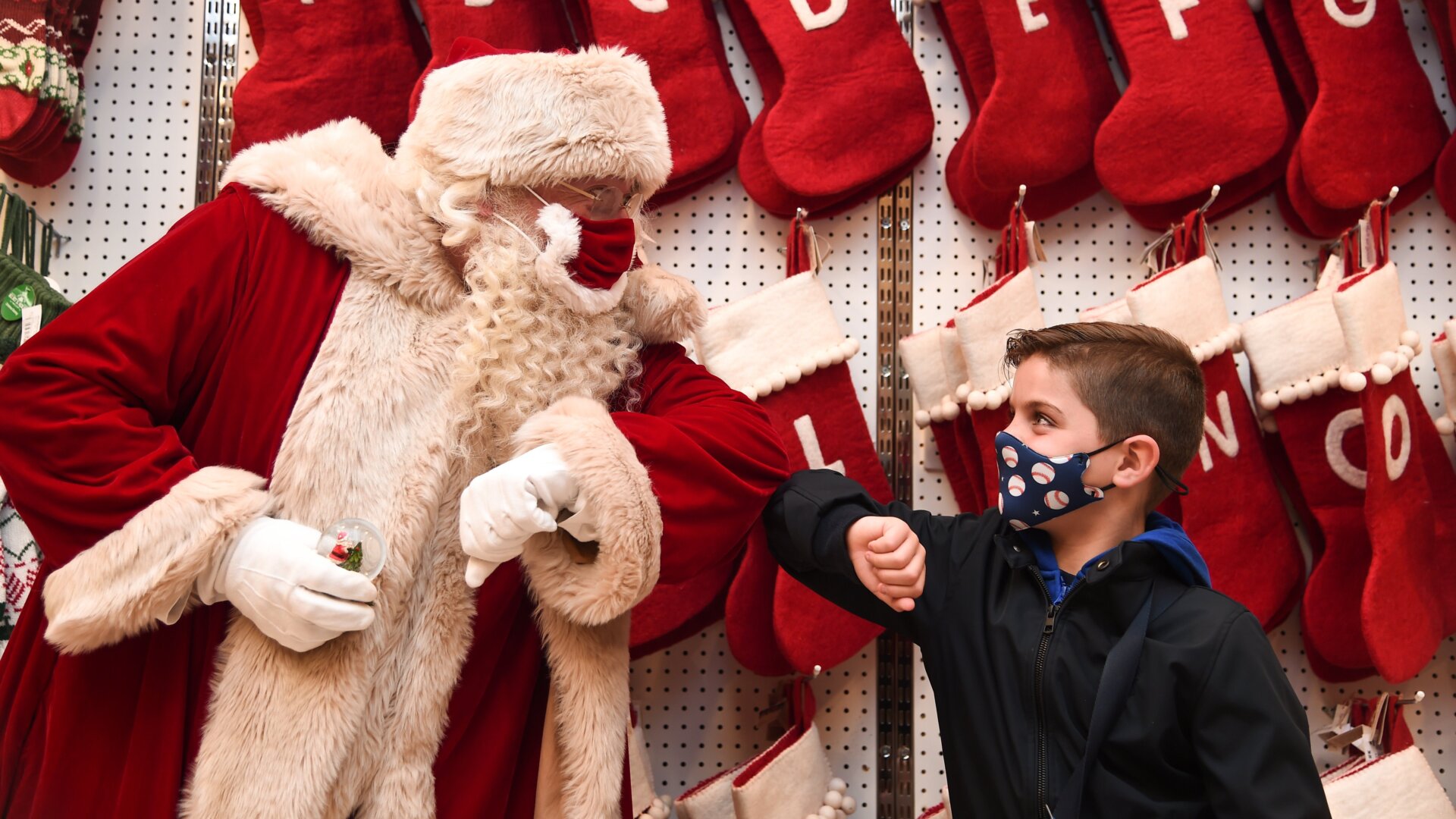 Santa Claus greets Jaythan Corbacho with an elbow bump during the Selfridges 2020 Christmas Shop “Once upon a Christmas” photocall at Selfridges, Oxford Street on October 12, 2020, in London, England.