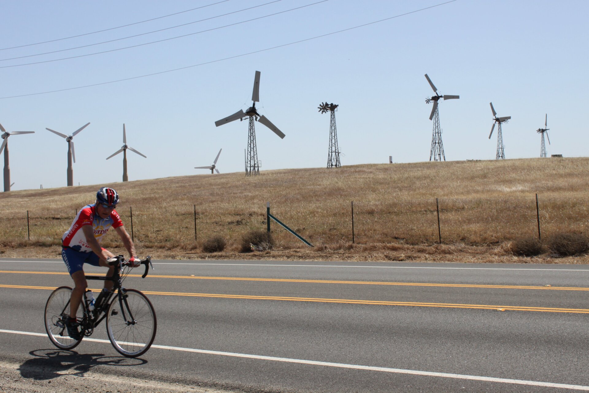 Multiple styles of wind turbines in various states of repair on Altamont Pass. Oh, and a biker.