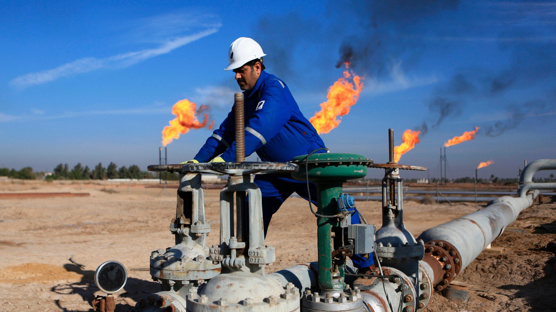 A worker operates valves in Nihran Bin Omar field north of Basra, Iraq.