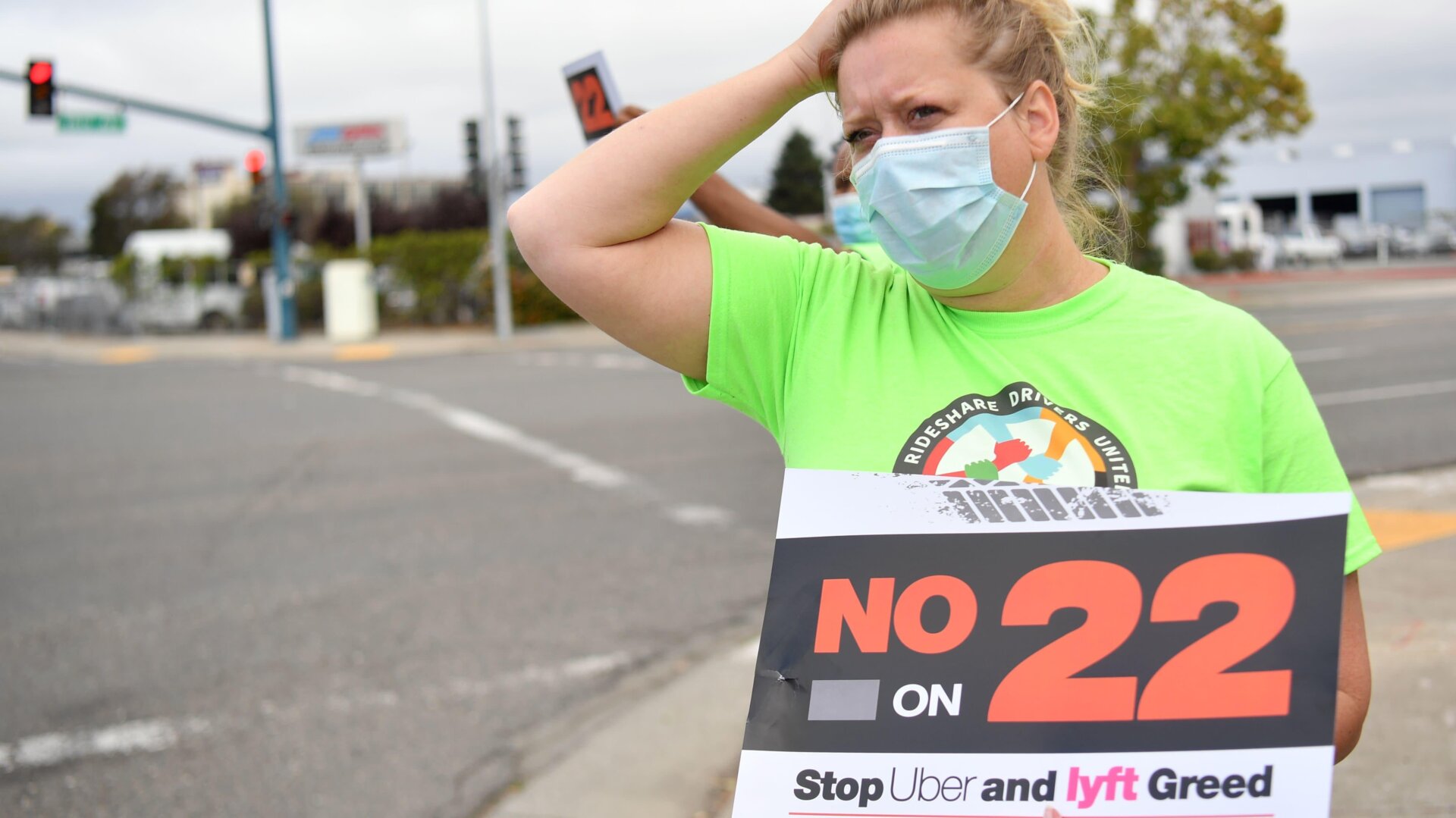 Rideshare driver Erica Mighetto holds up a a sign supporting a no vote on Proposition 22 in Oakland, California on October 9, 2020.