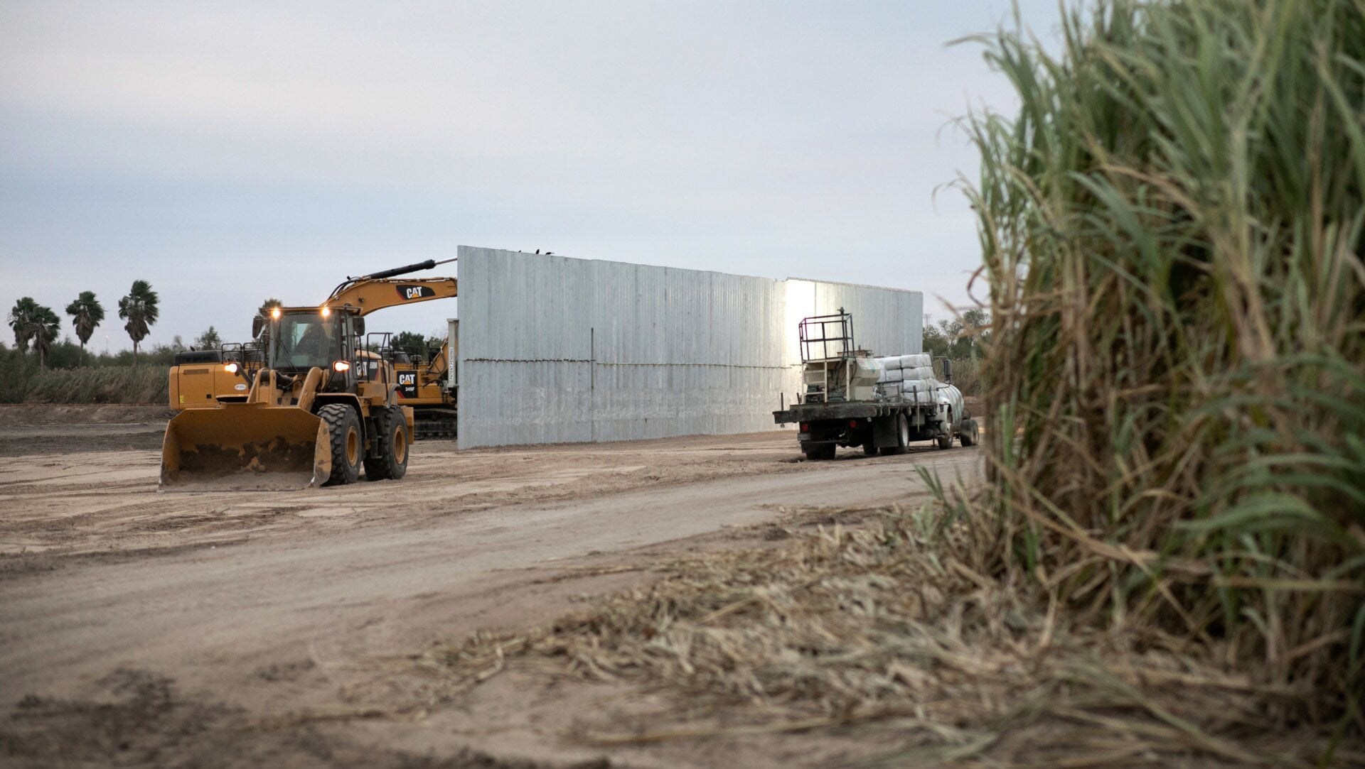 A loader grades land near a section of privately-built border wall under construction on December 11, 2019 near Mission, Texas.
