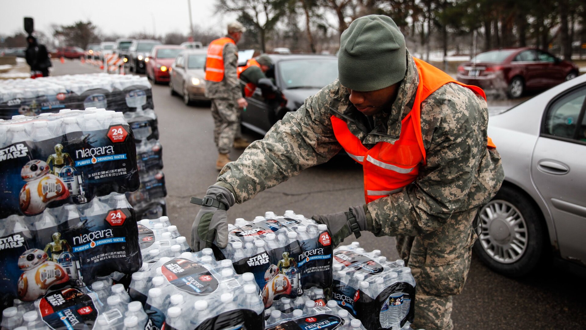 Army National Guard Specialist David Brown loads bottled water into waiting cars at a fire station on Jan. 21, 2016 in Flint, Michigan.