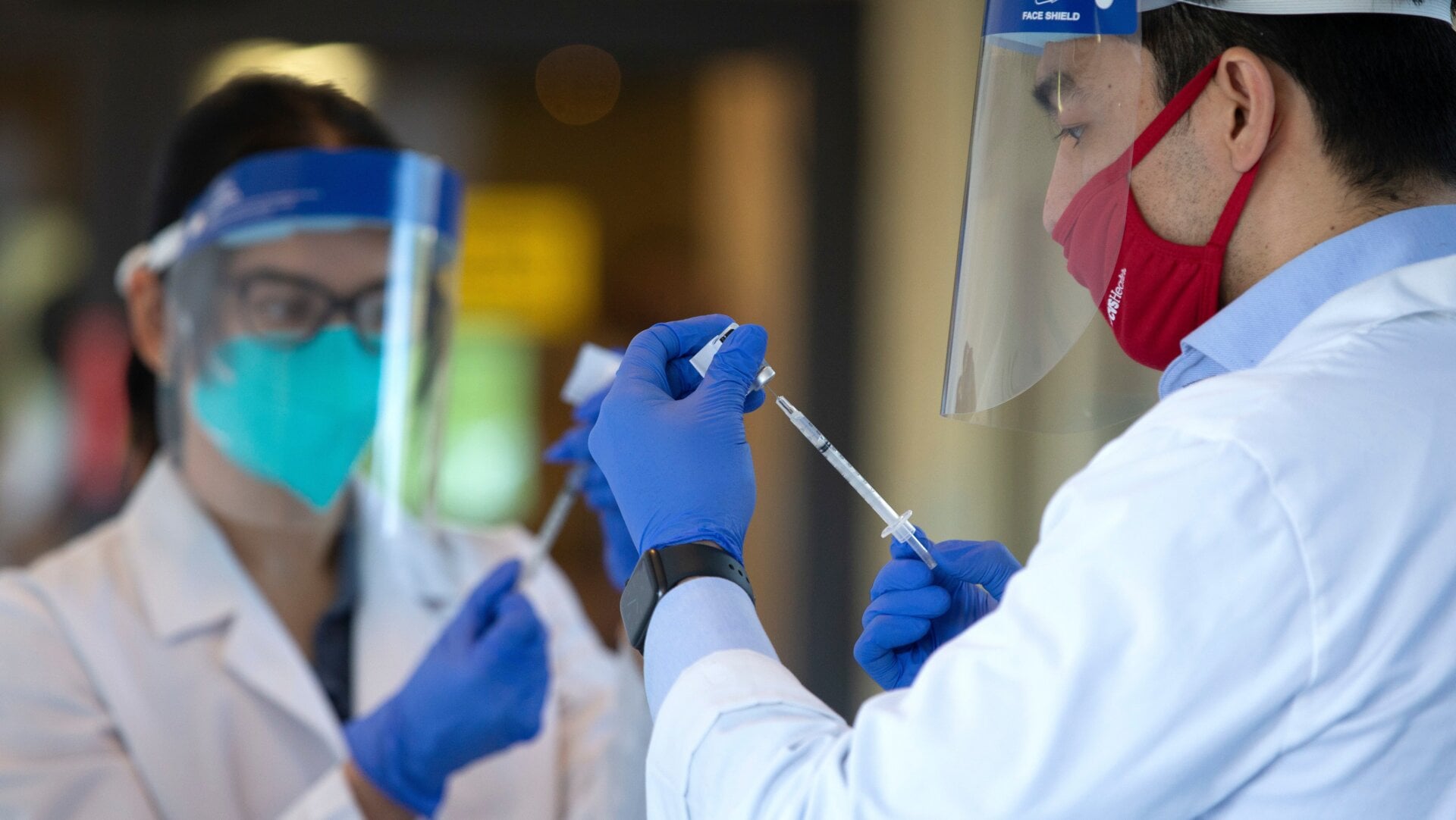 Pharmacists prepare doses of the covid-19 vaccine at the Life Care Center of Kirkland, Washington, an early epicenter of the coronavirus outbreak in the U.S.