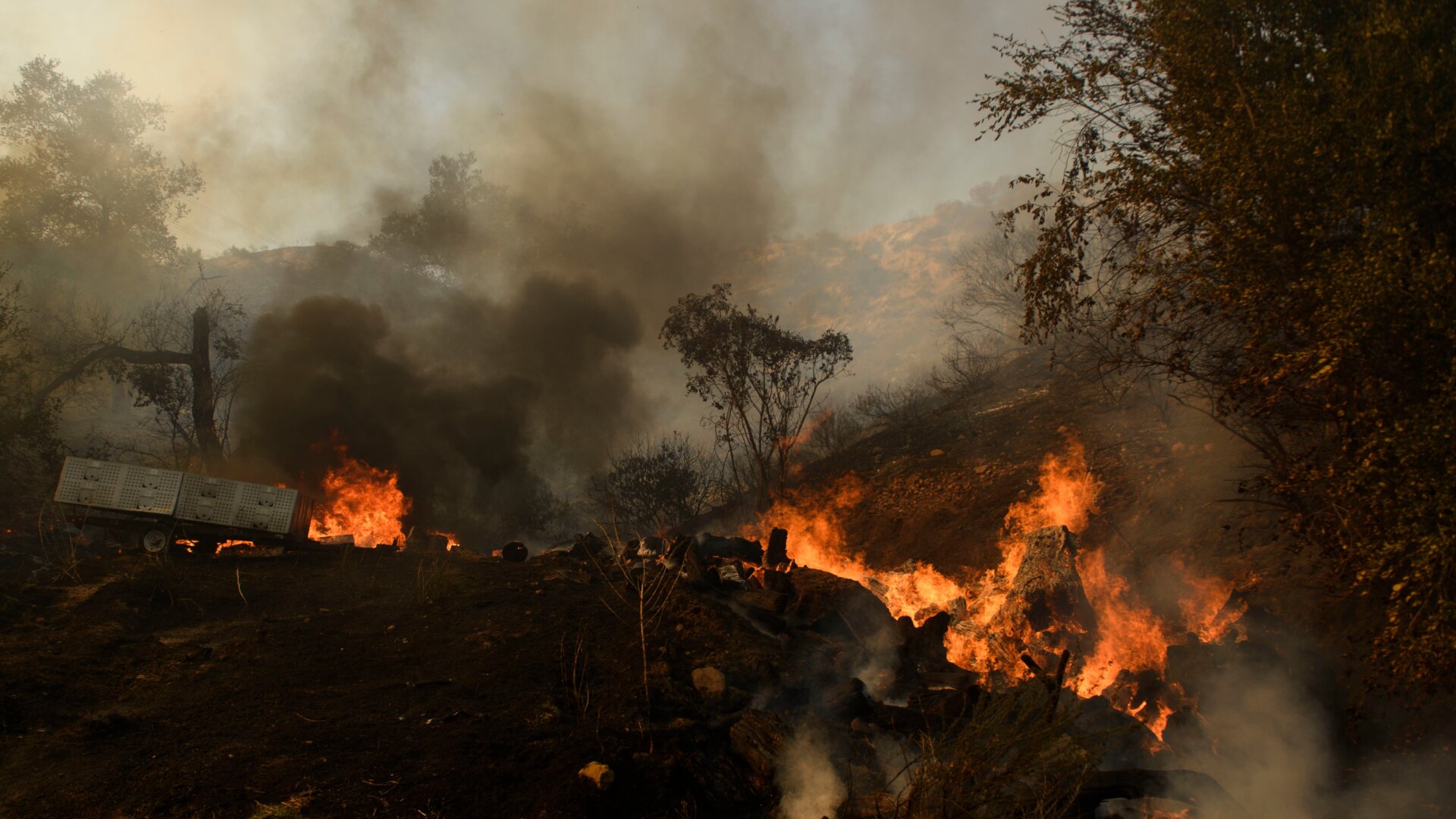 Debris burns behind a structure during the Bond Fire near Lake Forest, California on Dec. 3, 2020.