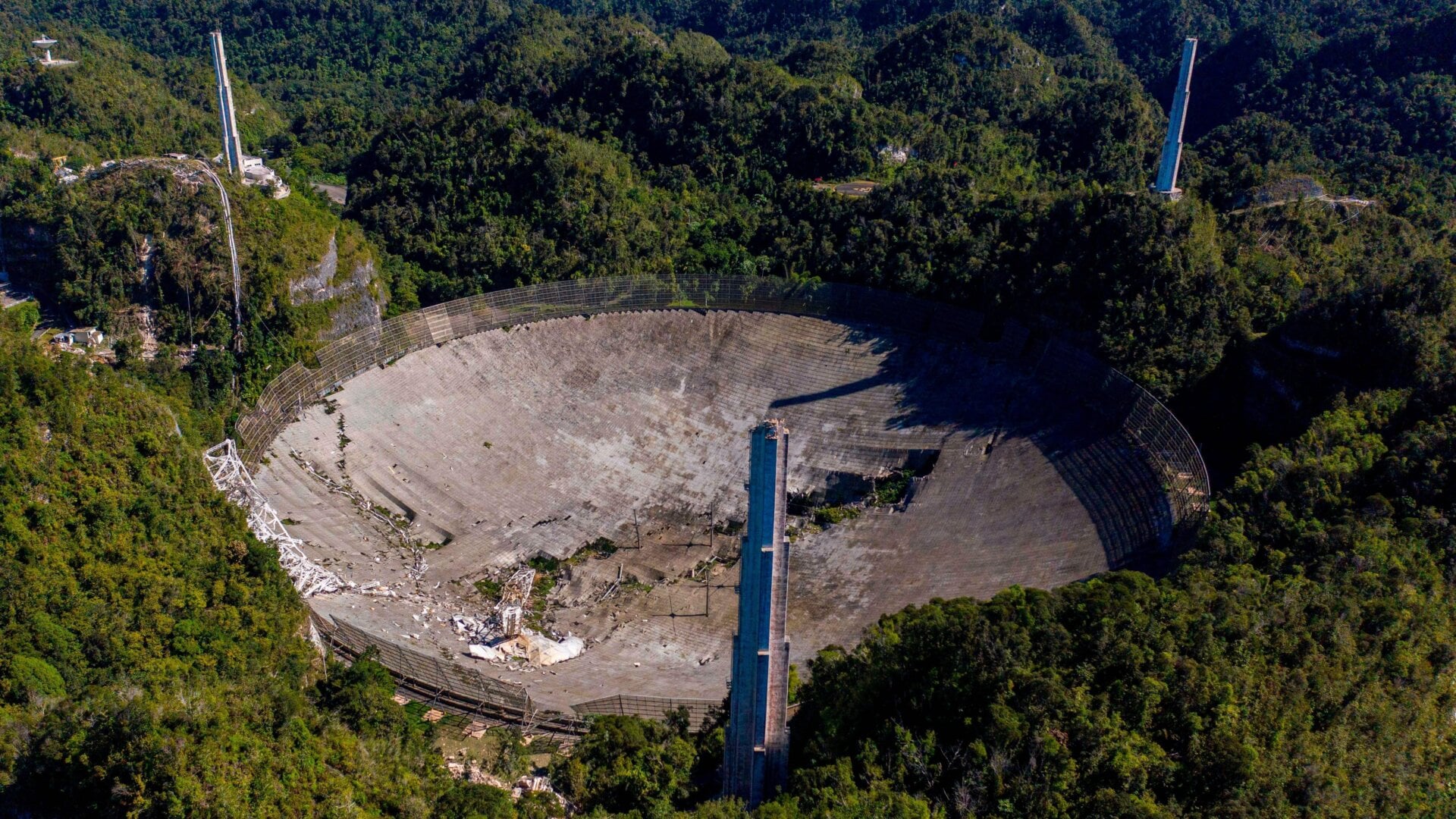 Aerial footage showing the damaged dish at the Arecibo Observatory and three support towers.