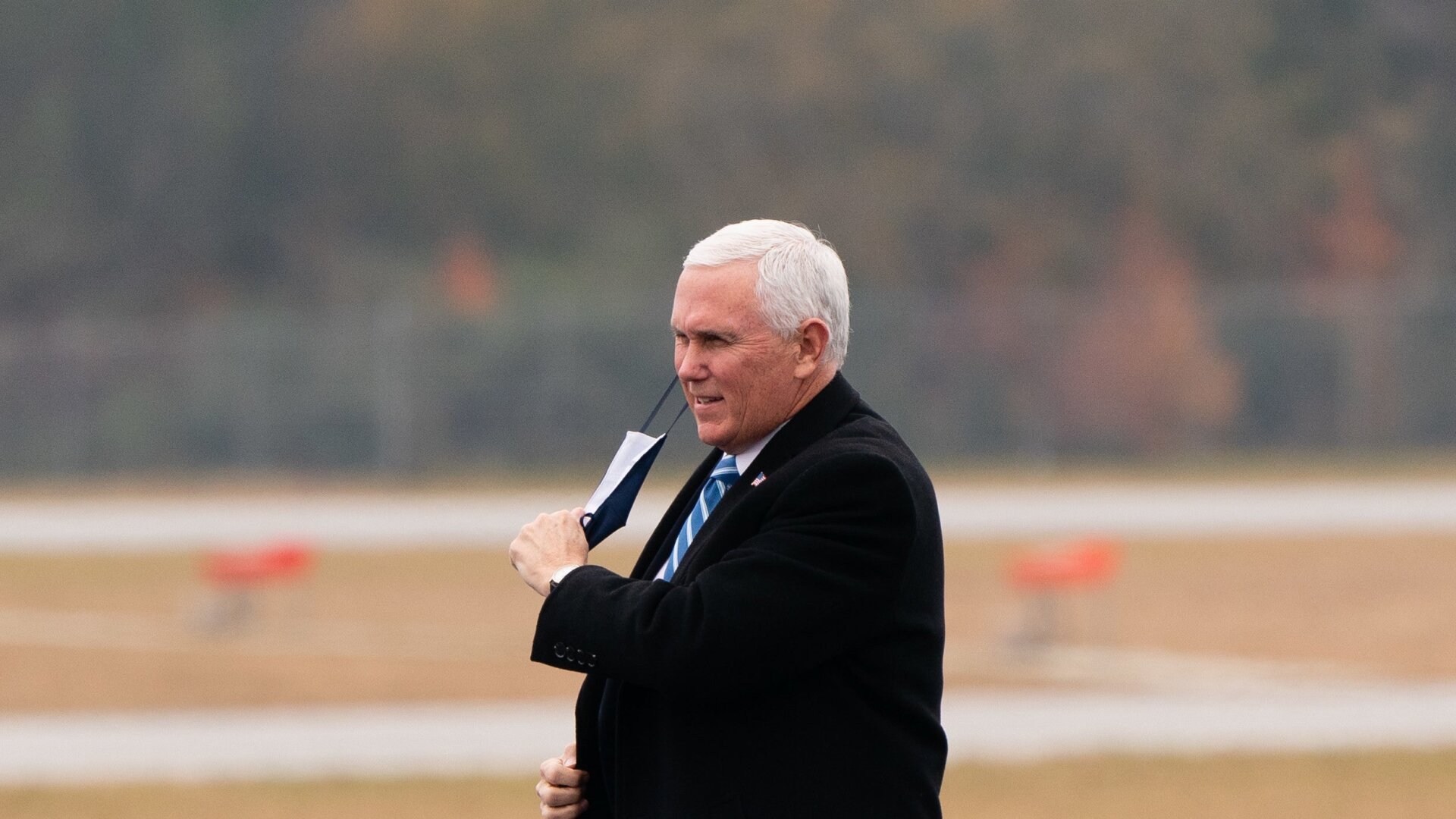 U.S. Vice President Mike Pence removes his face mask as he arrives for a “Defend The Majority” campaign event on December 17, 2020 in Columbus, Georgia.