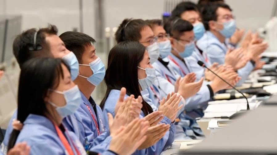 Mission controllers applauding the success of the mission. 